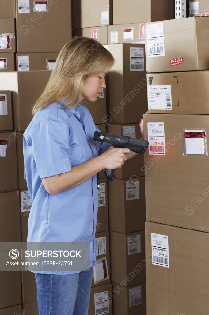 Female warehouse worker scanning package