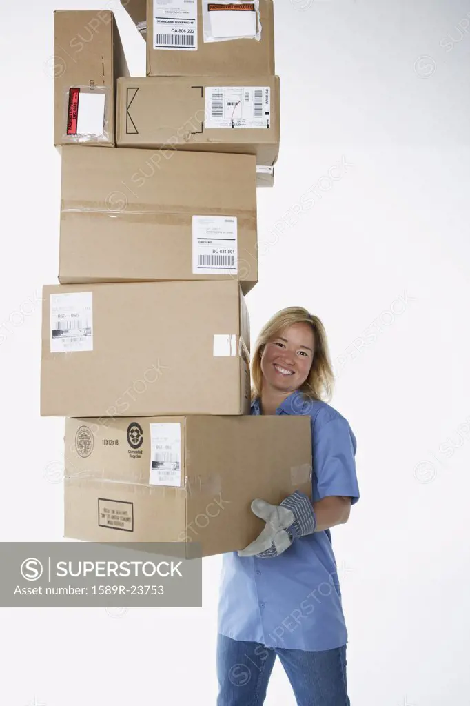 Studio shot of female warehouse worker carrying packages