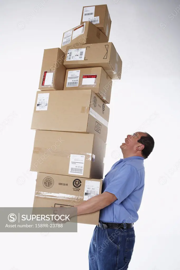 Studio shot of male warehouse worker carrying packages