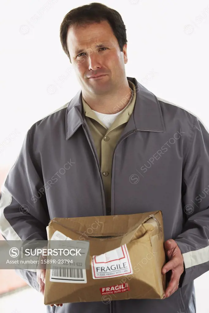 Man holding crushed package marked Fragile