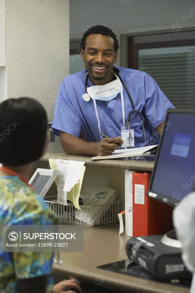 African male surgeon talking to nurse, Bethesda, Maryland, United States