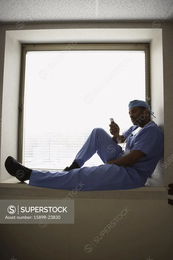 African male surgeon sitting in window alcove