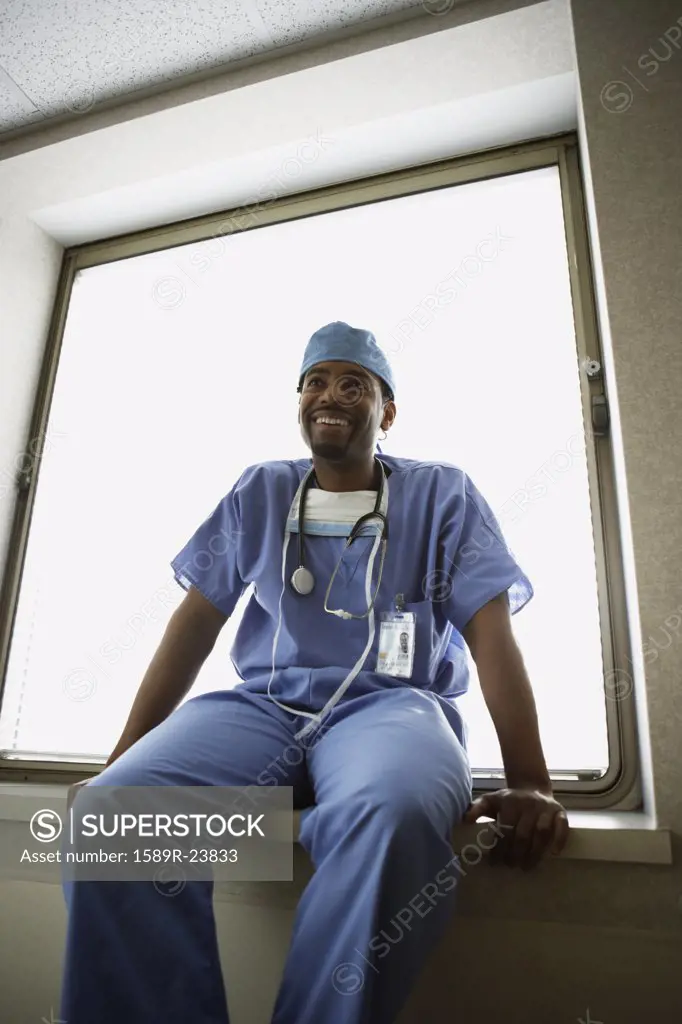 African male surgeon sitting in window alcove
