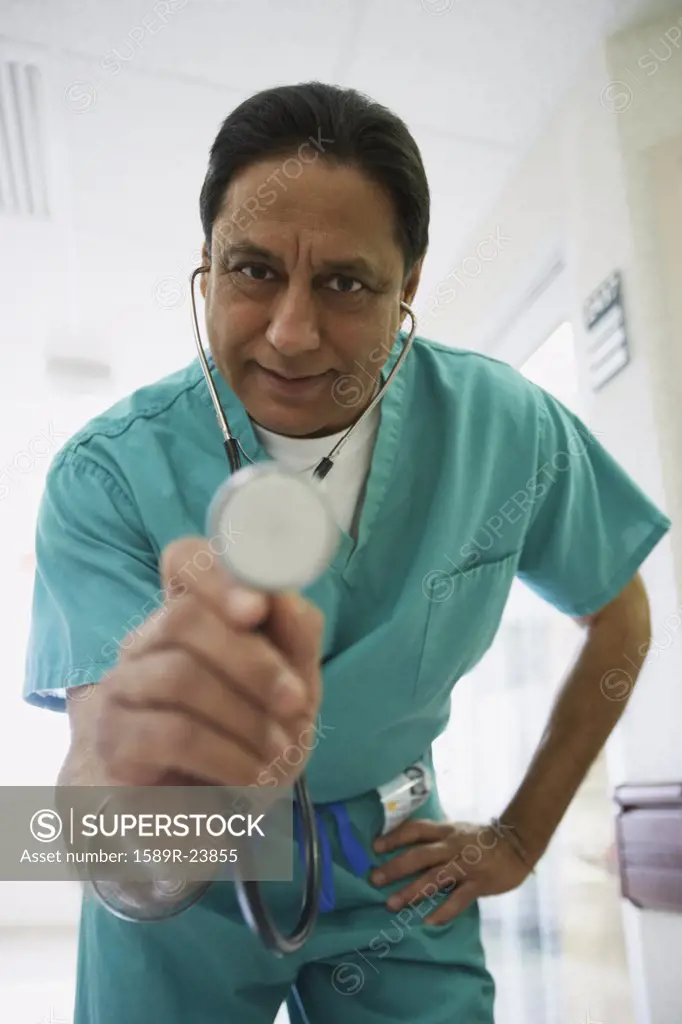 Middle-aged Indian male doctor holding out stethoscope, Bethesda, Maryland, United States