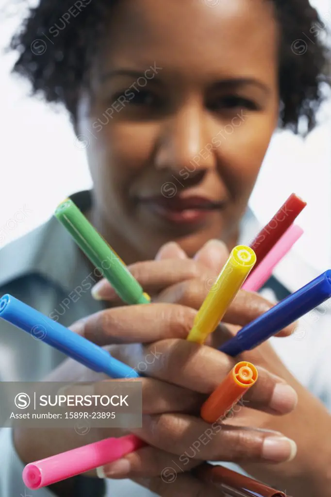 African American woman holding multicolored markers in hands
