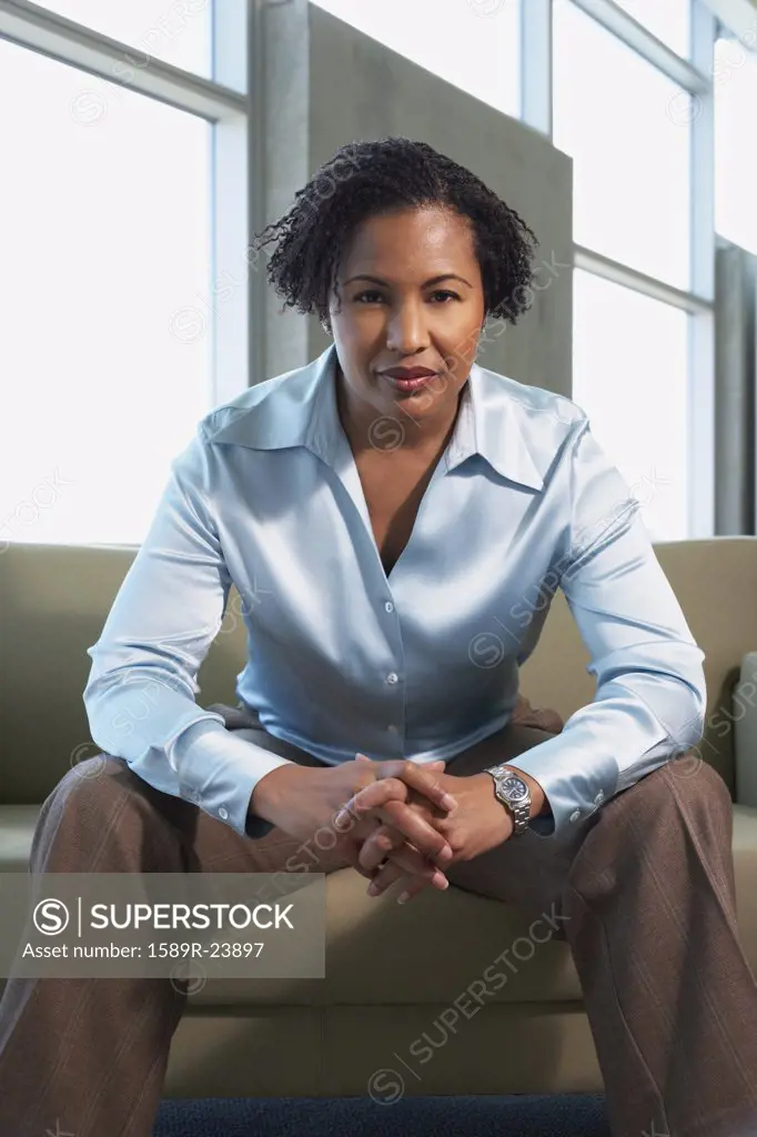 African American businesswoman sitting on sofa
