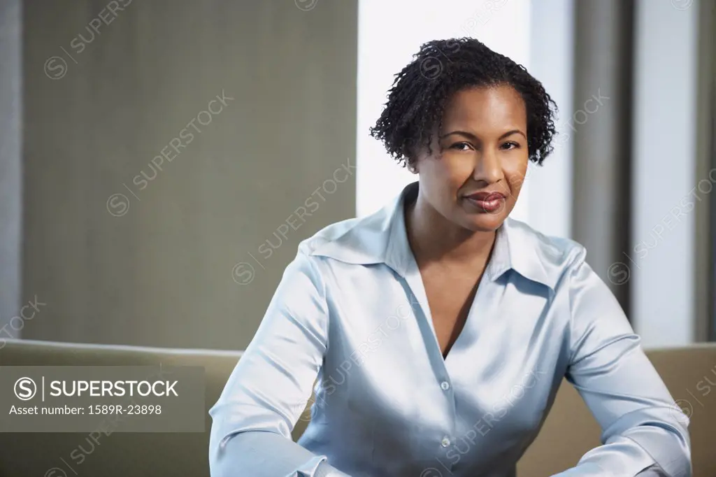 African American businesswoman sitting on sofa