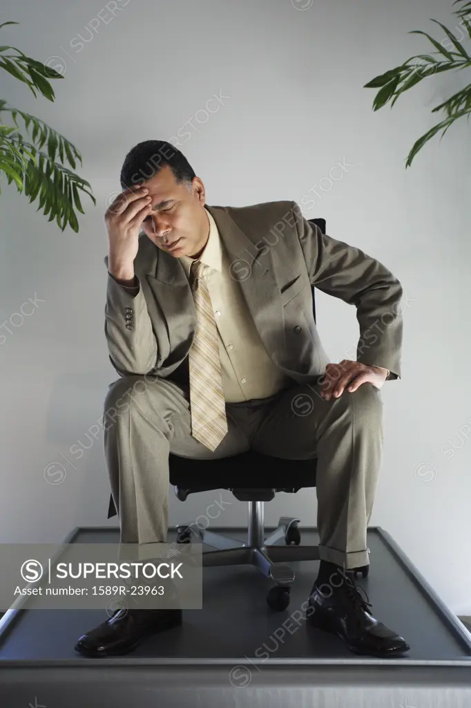 African American businessman sitting in chair on pedestal