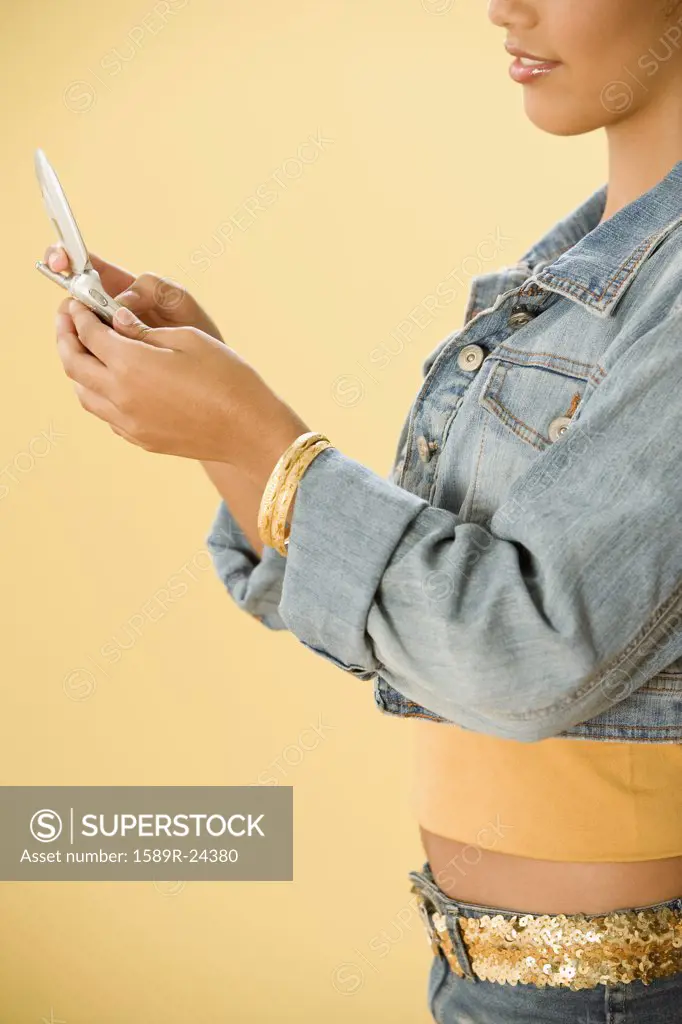 Studio shot of a female Dominican teenager using cell phone