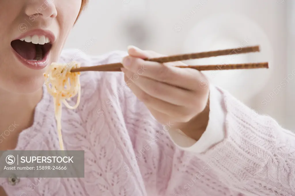Woman eating with chopsticks
