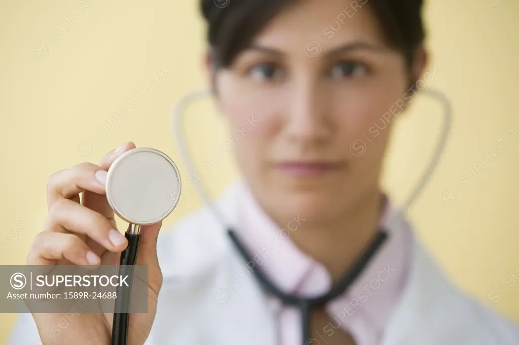 Hispanic female doctor holding up stethoscope