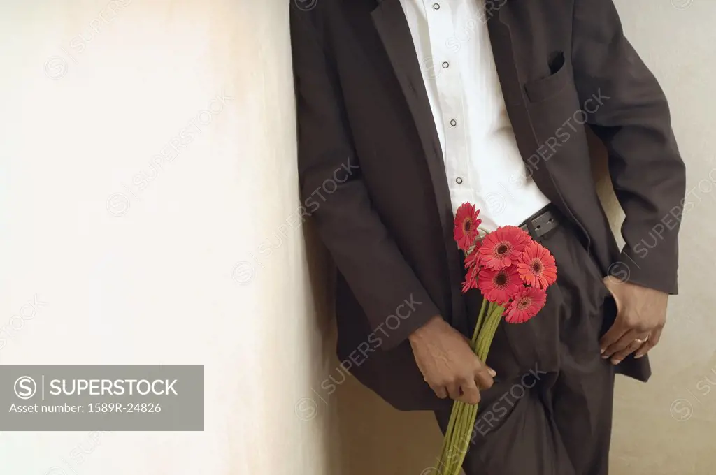 African American man in suit holding flowers
