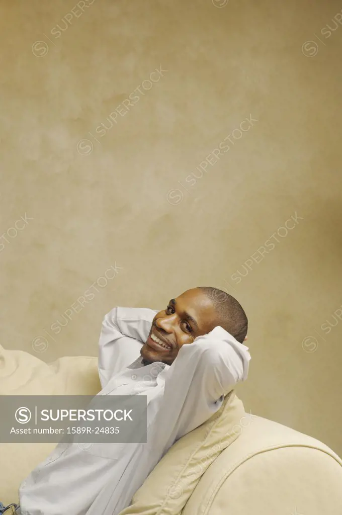 African American man sitting on sofa