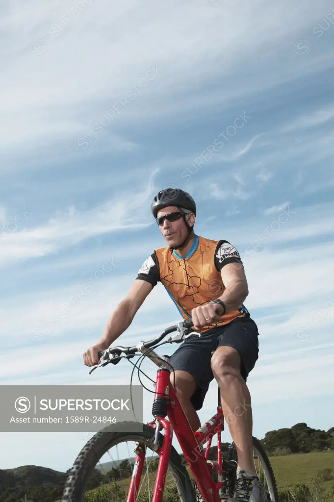 Male cyclist riding under blue sky, California, United States