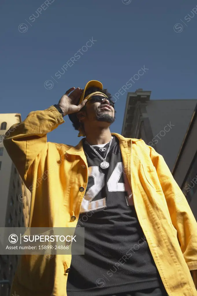 Low angle view of young African man standing in urban area, Oakland, California, United States