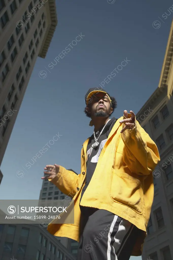 Young African man dancing in urban area, Oakland, California, United States
