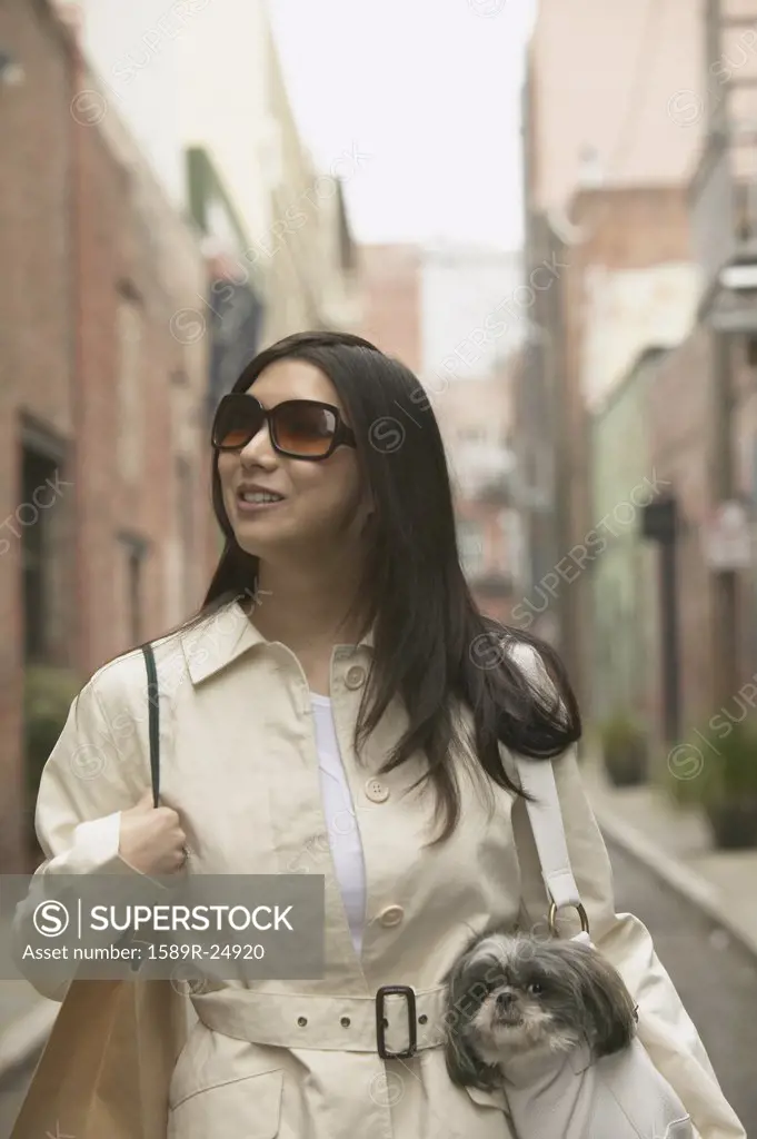 Young Asian woman with small dog in urban area, San Francisco, California, United States