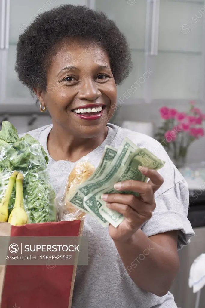 Senior African American woman with money and groceries
