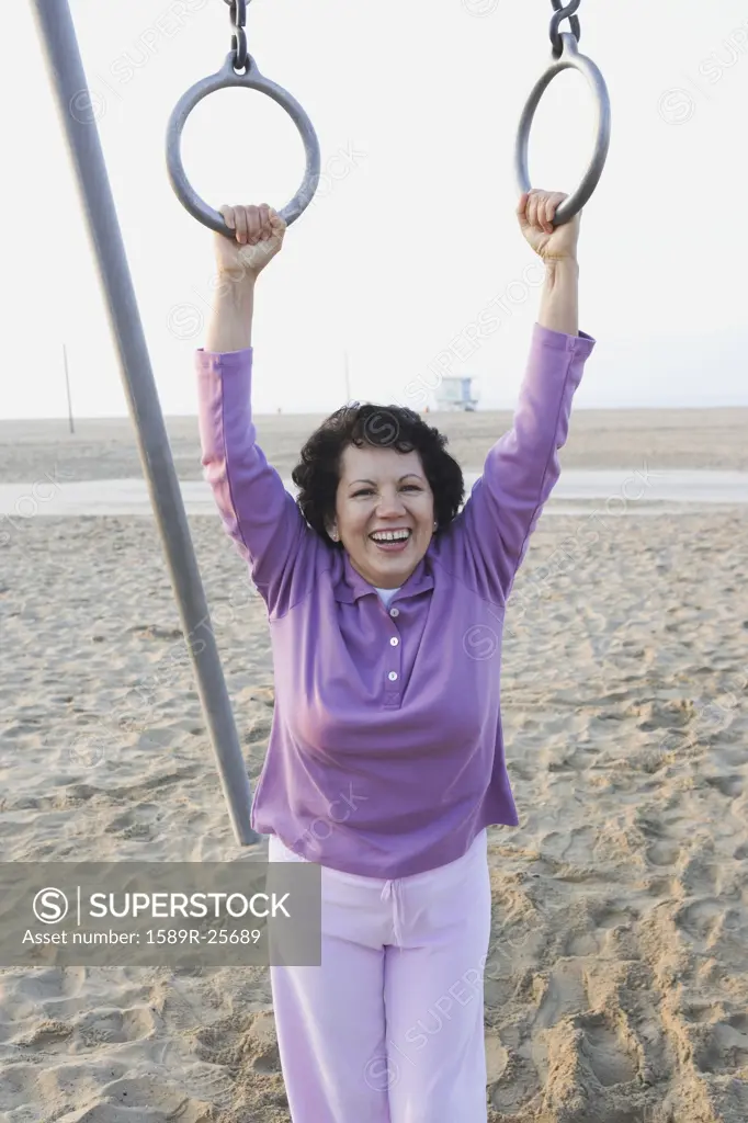 Senior woman holding on to rings at the beach