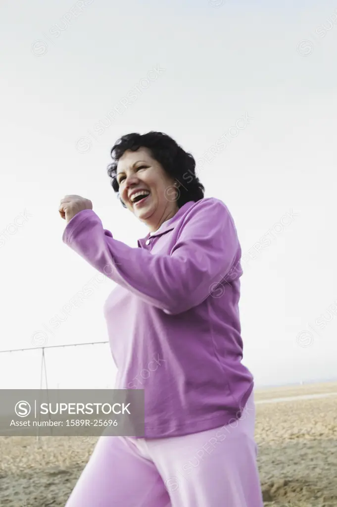 Senior woman jogging on the beach