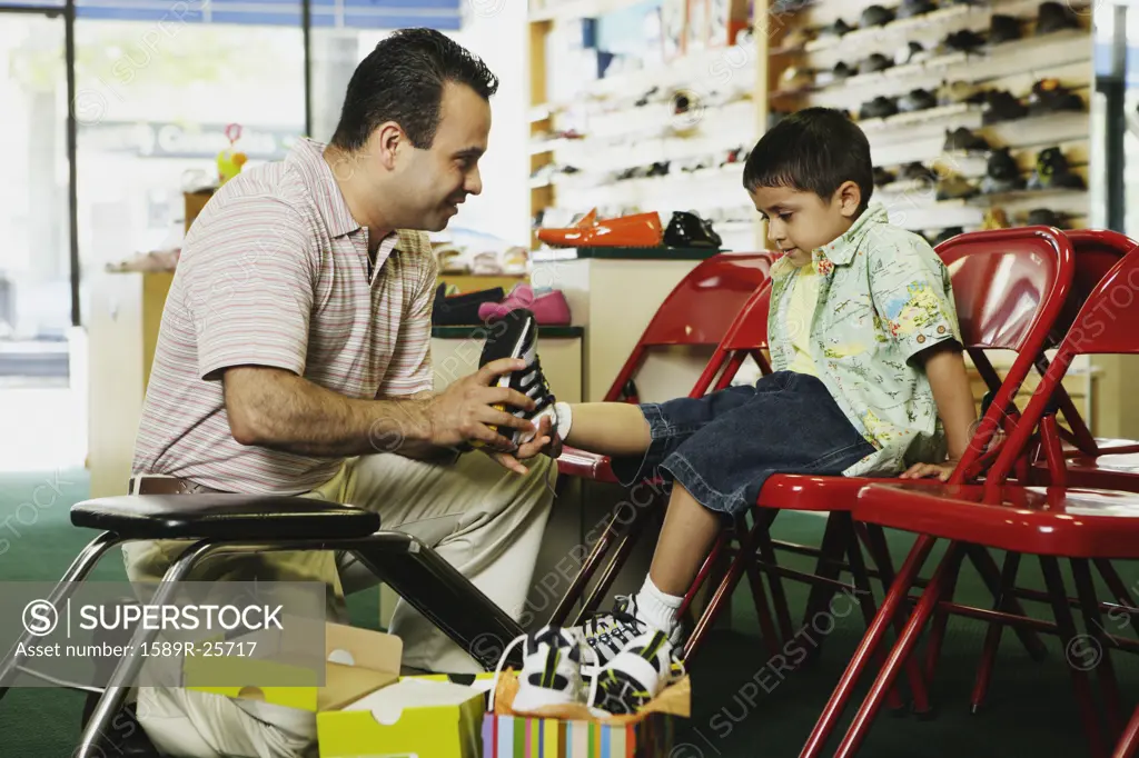 Young Hispanic boy trying shoes at shoe store, Port Washington, New York, United States