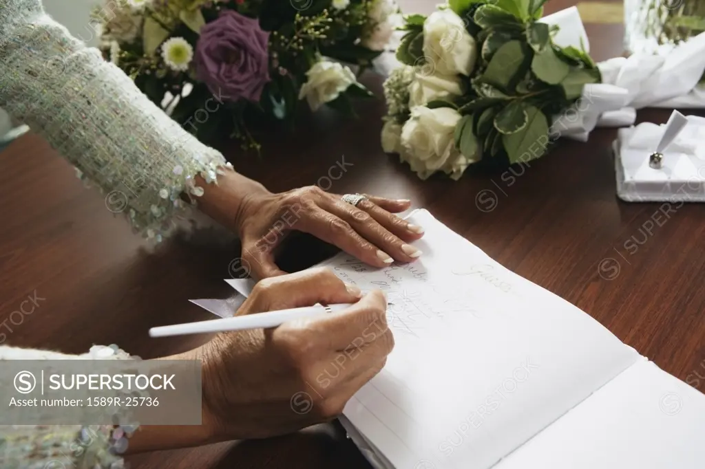 Woman signing wedding guestbook, Sands Point, New York, United States