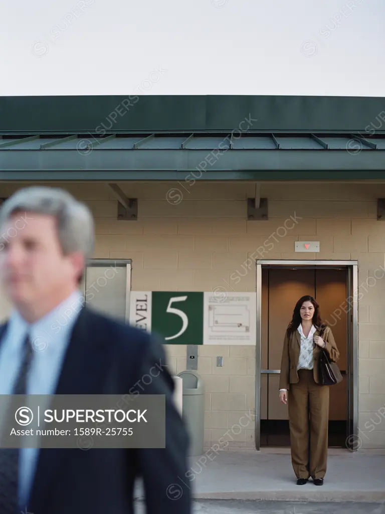 Businesswomen next to elevator at parking garage, Dallas, Texas, United States