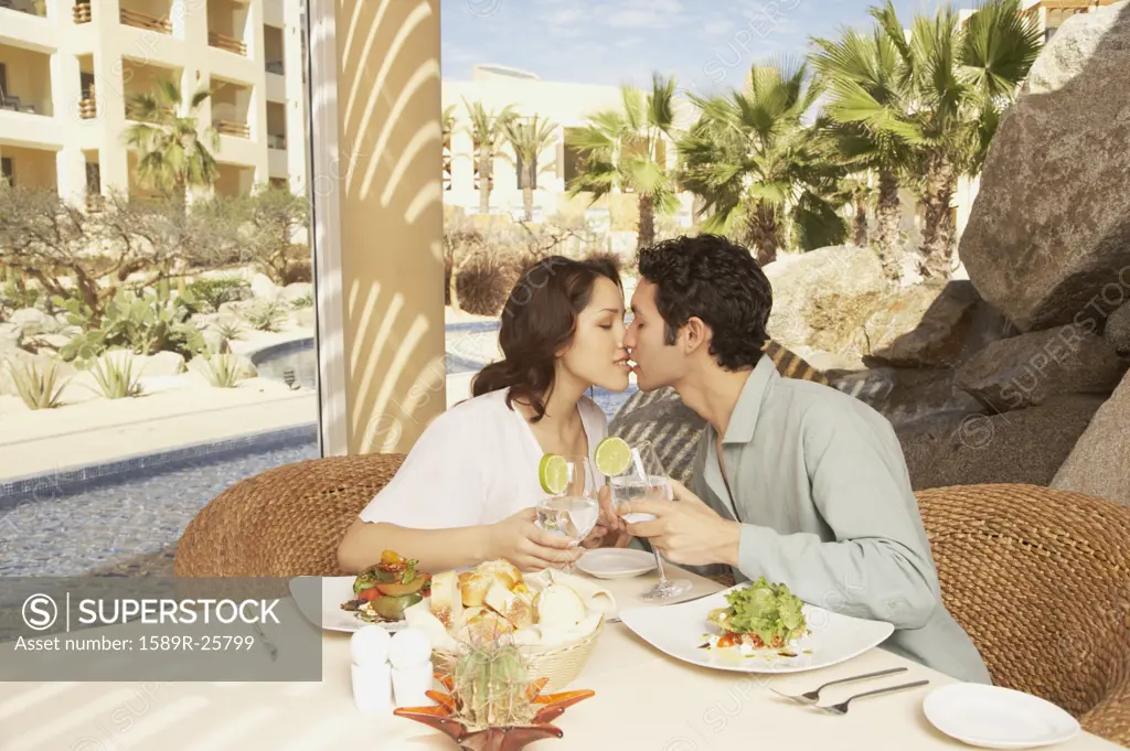 Couple kissing at the table in a resort hotel, Los Cabos, Mexico