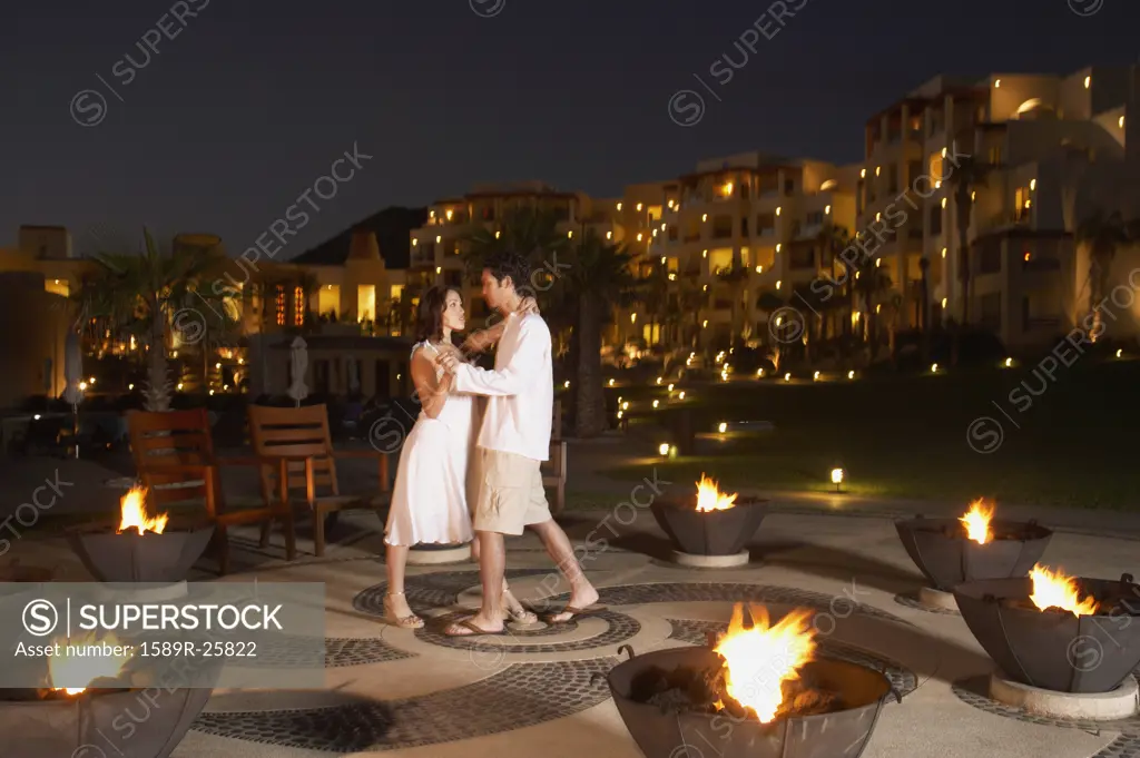 Couple dancing outdoors at resort hotel at night, Los Cabos, Mexico