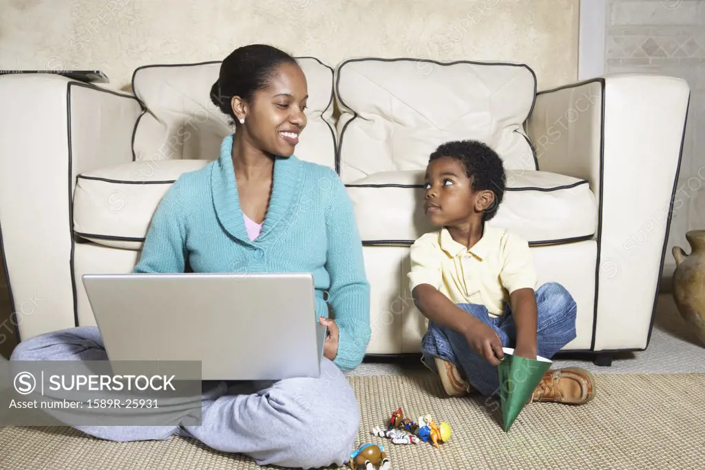 African American mother sitting with son and laptop
