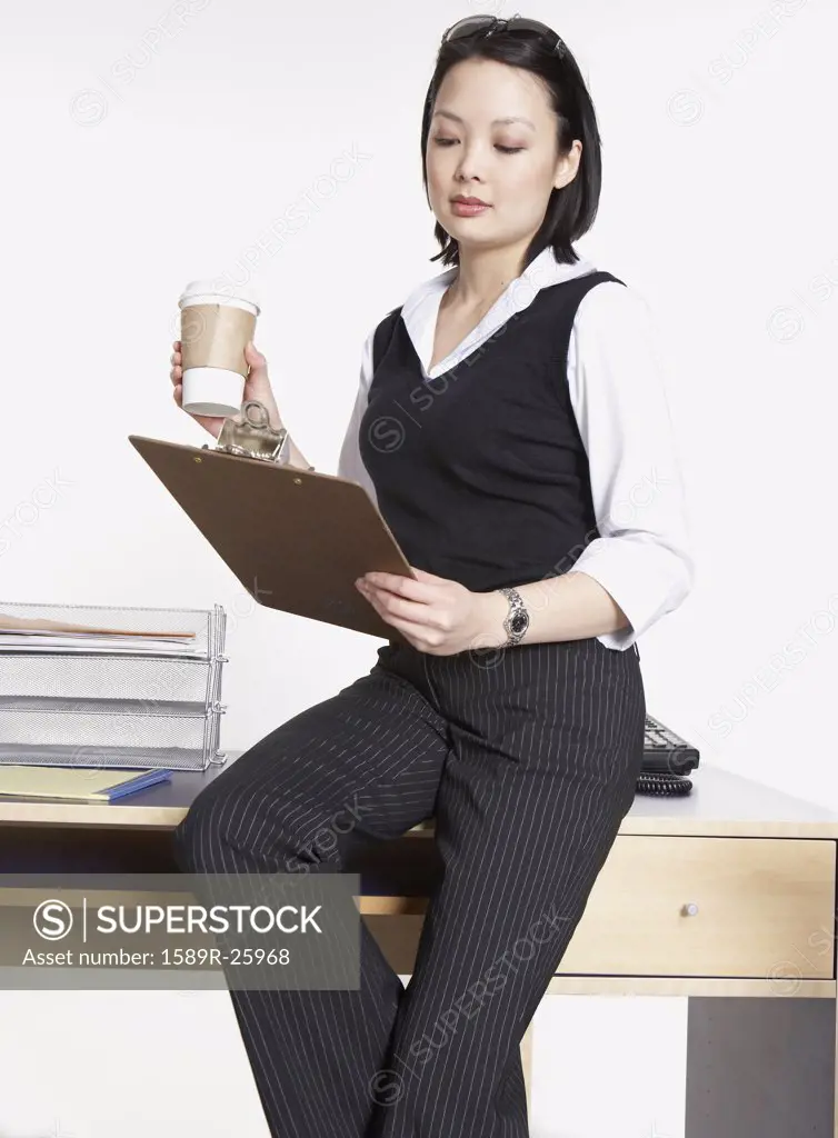 Studio shot of Asian businesswoman with clipboard