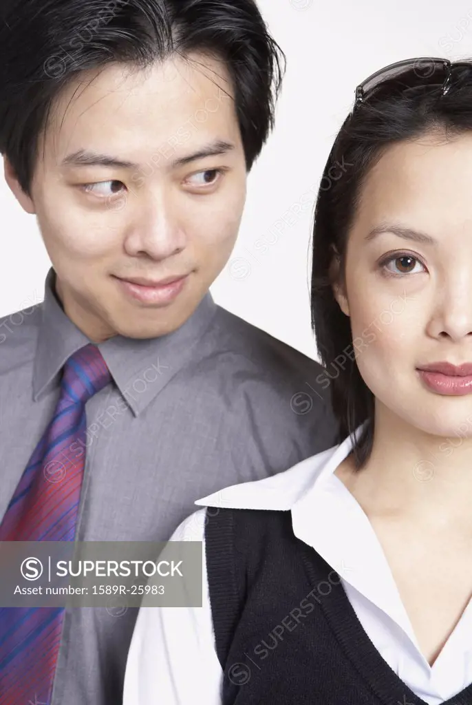 Close up of Asian businessman looking at Asian businesswoman