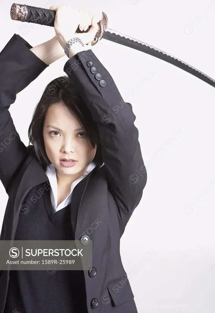 Studio shot of Asian businesswoman holding sword