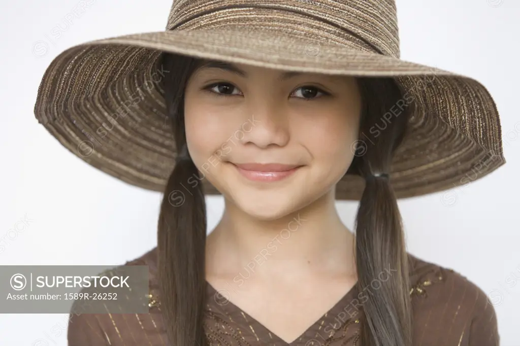 Studio shot of young Hispanic girl with hat