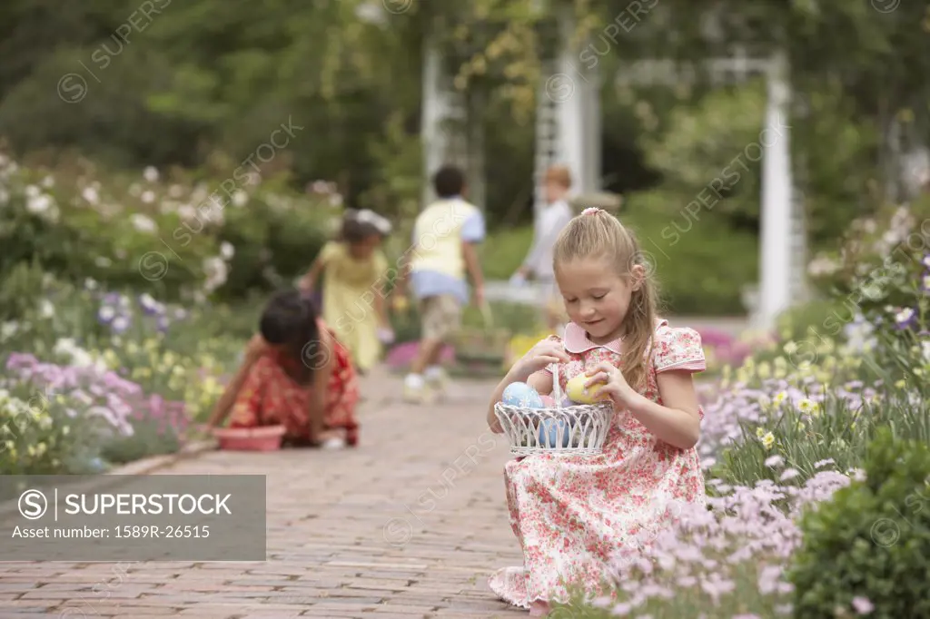 Children gathering Easter eggs in garden