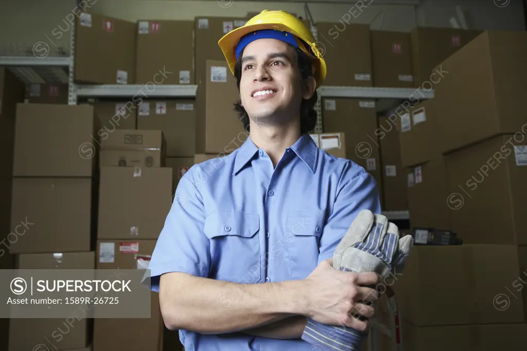 Hispanic male warehouse worker with boxes