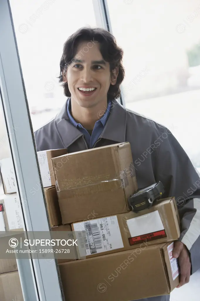 Male delivery person with stack of boxes