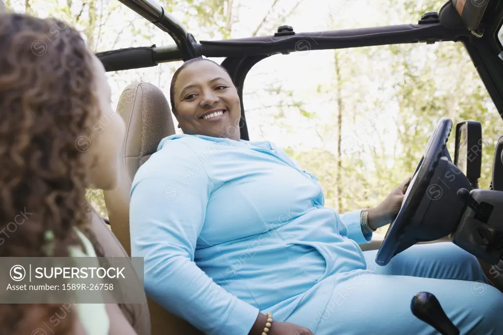 African mother and daughter sitting in jeep smiling