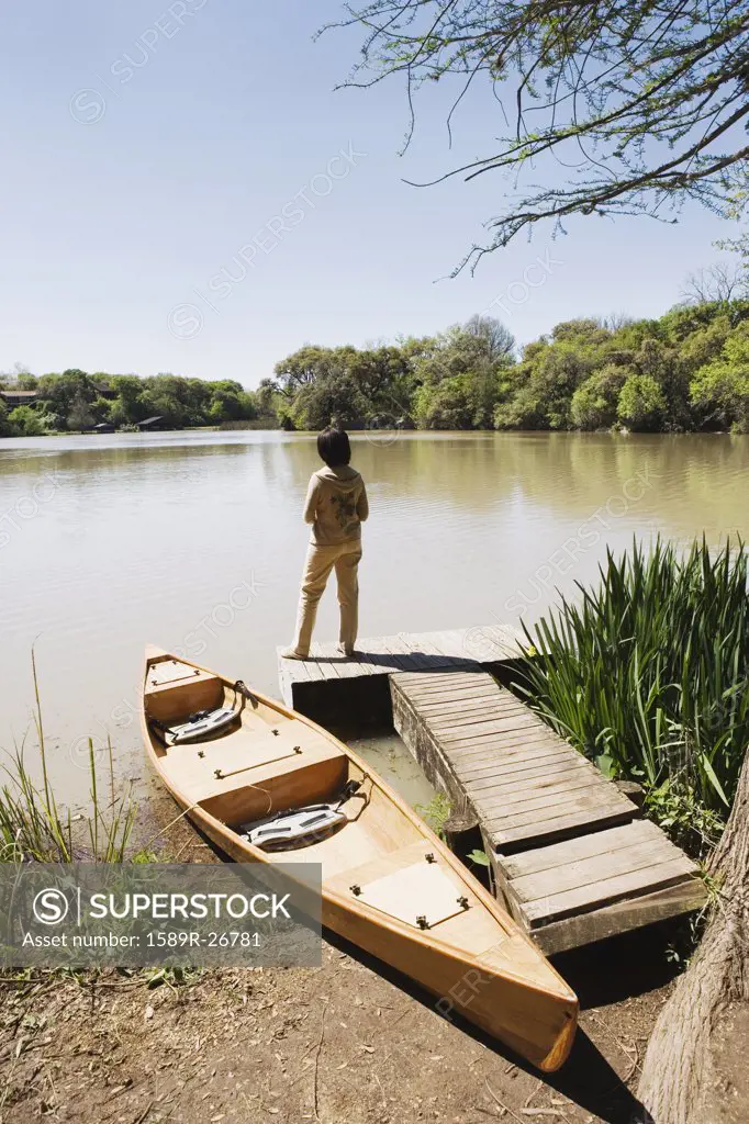 Woman standing on dock next to canoe