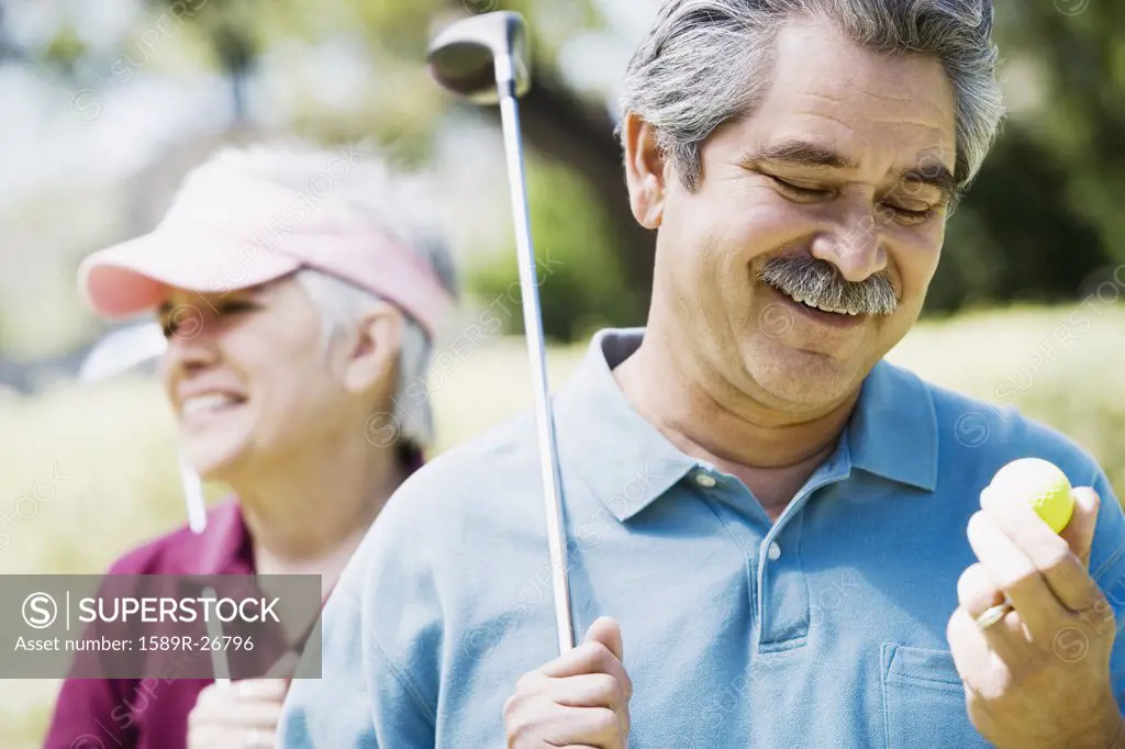 Middle-aged couple with golf clubs