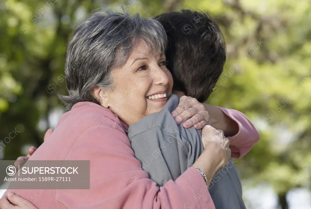 Hispanic grandmother hugging grandson