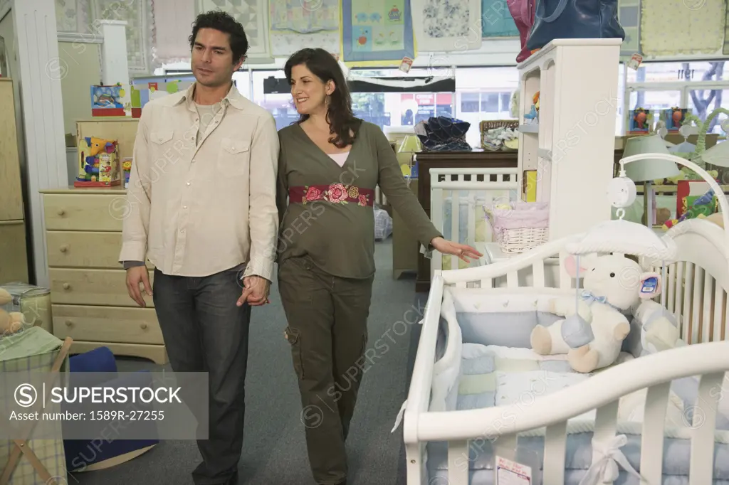 Pregnant couple shopping for baby furniture