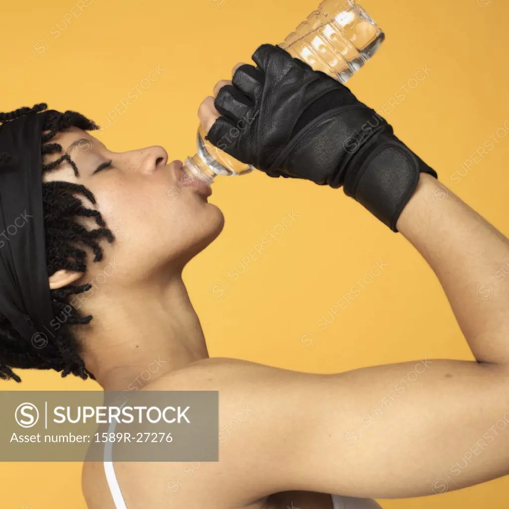 Studio shot of African woman drinking bottle of water