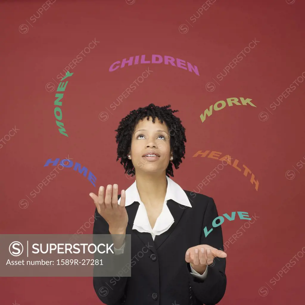 African businesswoman juggling words representing busy life