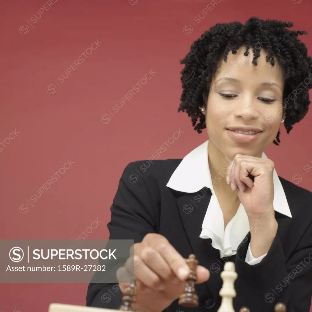 Studio shot of African woman playing chess