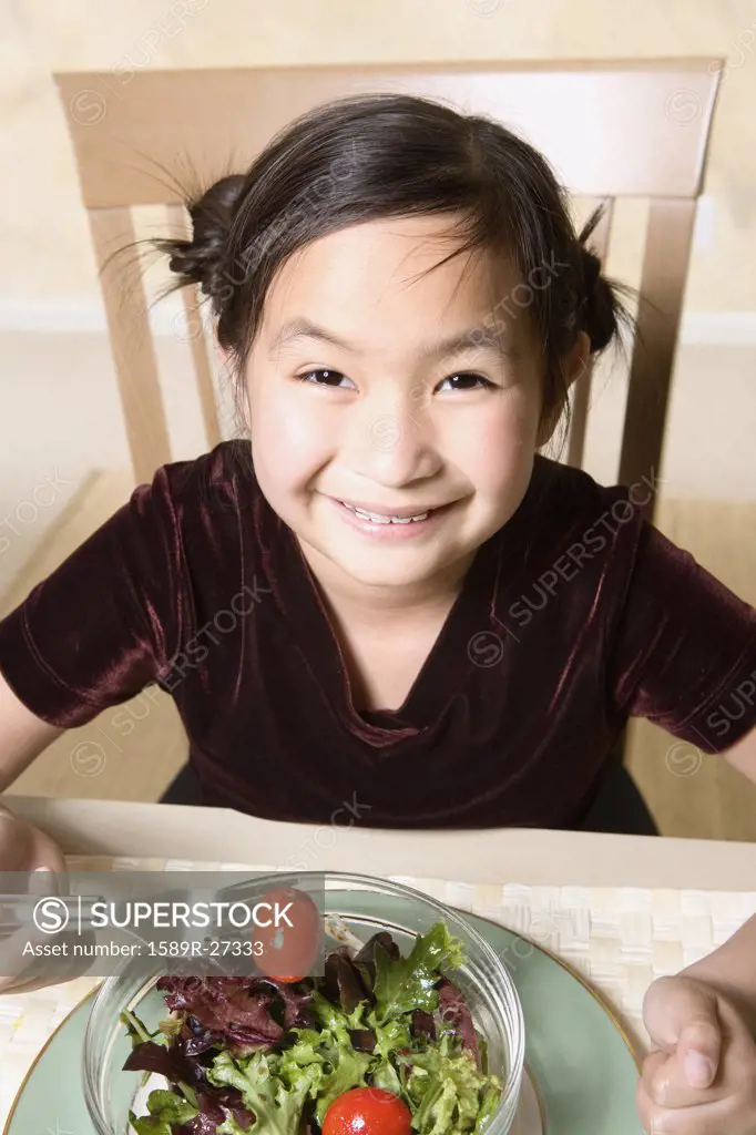 Young Asian girl eating salad