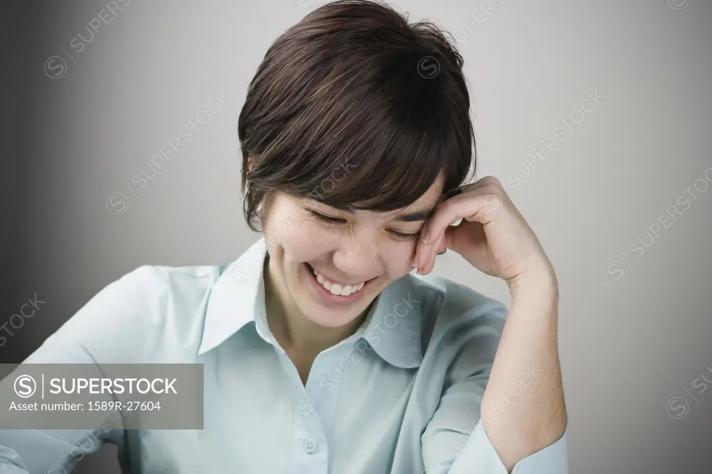 Young woman laughing with head down
