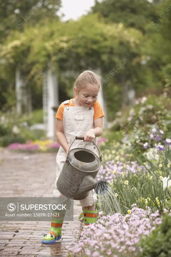 Girl using watering can in garden