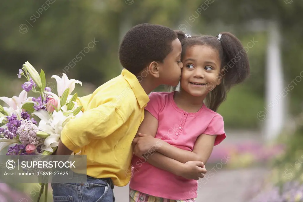 Young African boy kissing young African girl on cheek