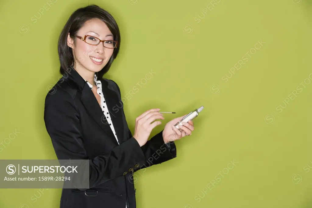 Studio shot of Asian businesswoman with electronic organizer